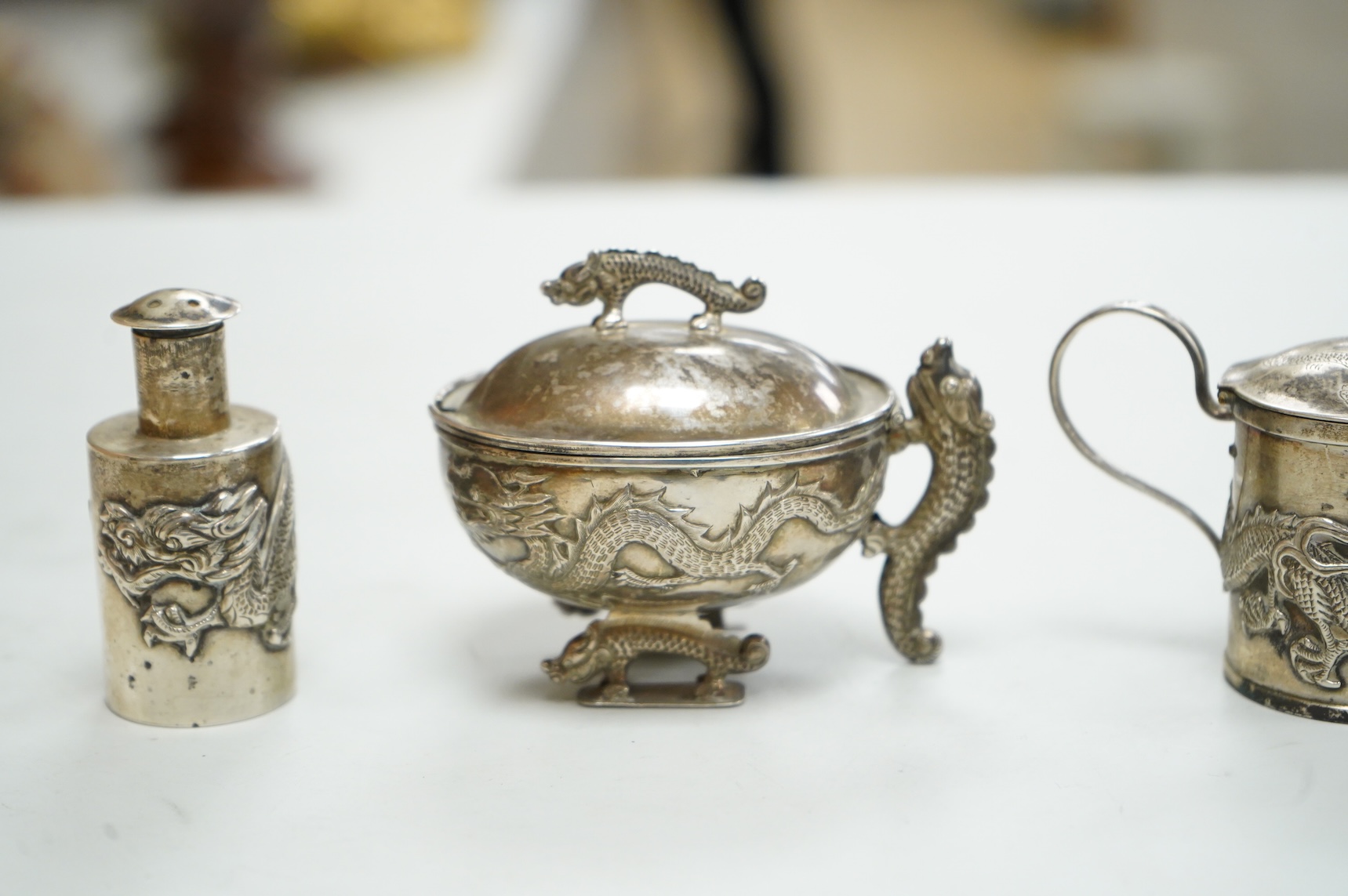 Three early 20th century Chinese export white metal condiments including a drum mustard pot and pepperette by Wang Hing, Hong Kong, pepperette 63mm.